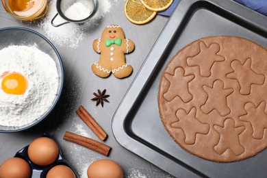 Making homemade gingerbread man cookies on grey table, flat lay