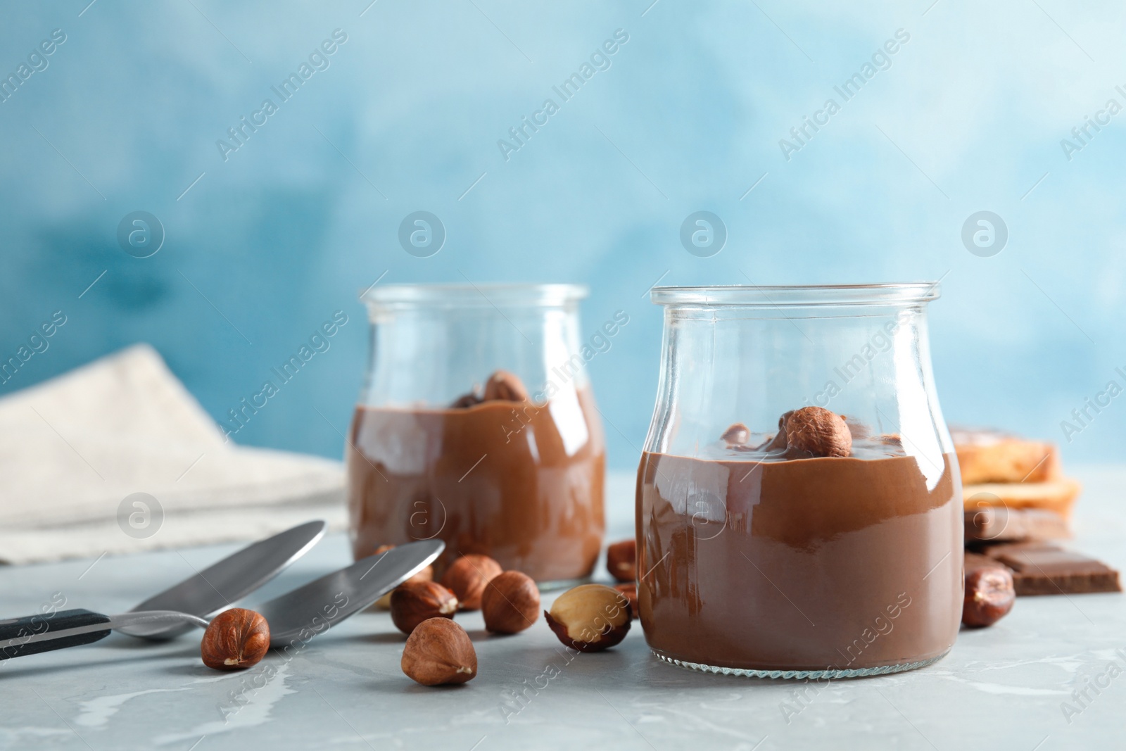 Photo of Glass jars with tasty chocolate cream served on table