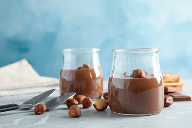 Glass jars with tasty chocolate cream served on table