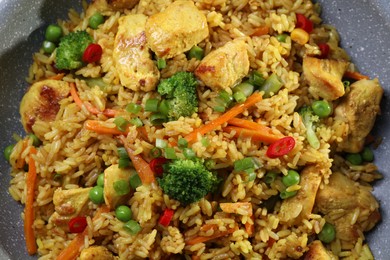 Photo of Tasty rice with meat and vegetables in frying pan, top view