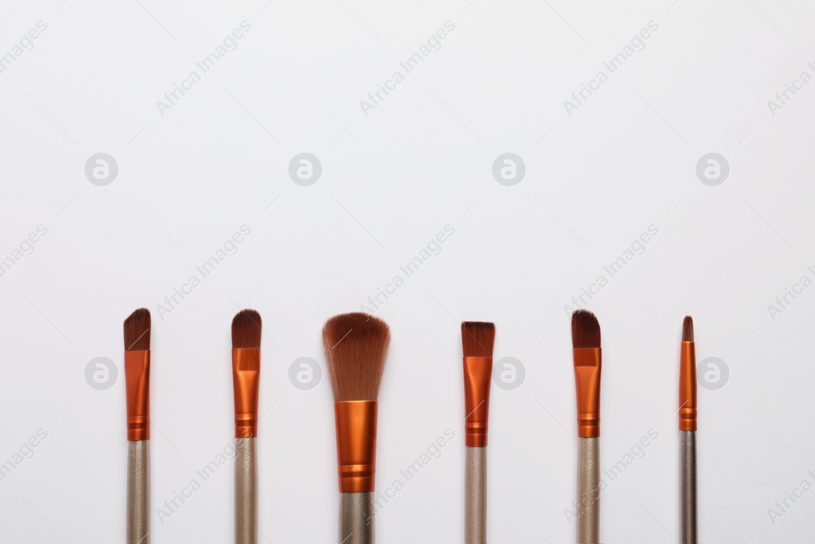 Photo of Set of makeup brushes on white background, flat lay. Space for text