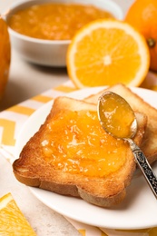 Delicious toasts with orange marmalade on table, closeup