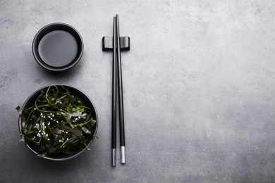 Fresh laminaria (kelp) seaweed served on gray table, flat lay. Space for text