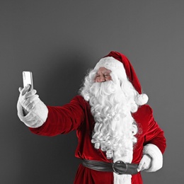Photo of Authentic Santa Claus taking selfie on grey background. Space for text