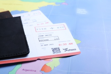 Photo of Passports with tickets on world map, closeup. Travel agency concept