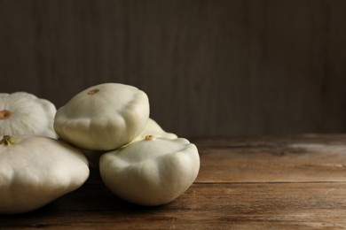 Fresh ripe pattypan squashes on wooden table. Space for text