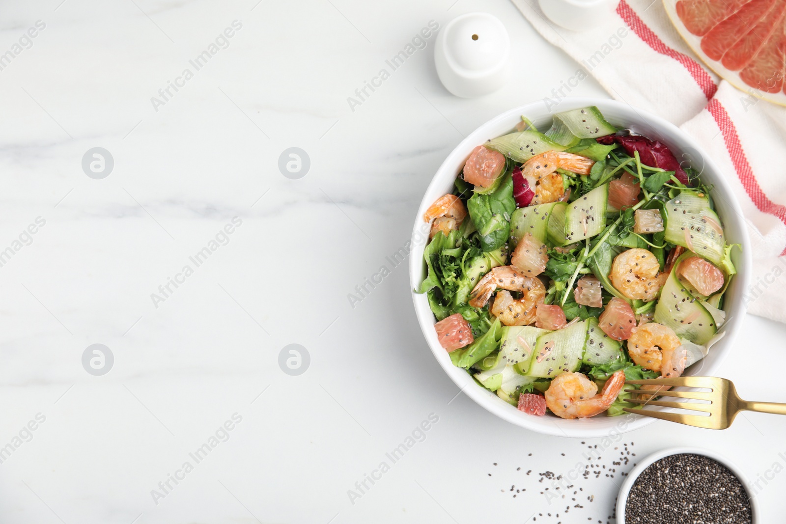 Photo of Delicious pomelo salad with shrimps served on white  table, flat lay. Space for text