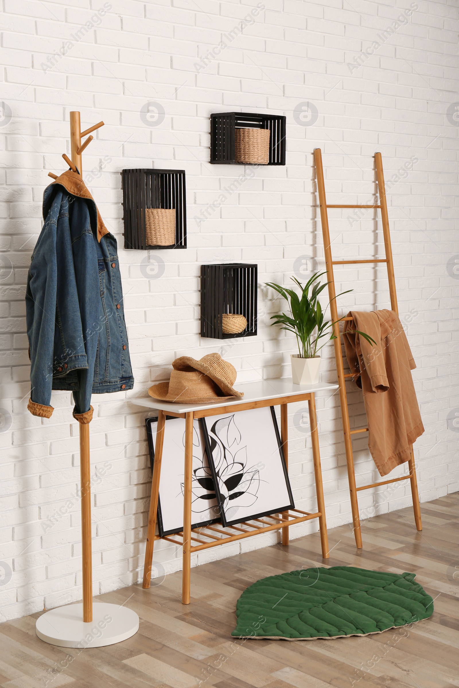 Photo of Stylish hallway interior with hanger stand, table and decorative wooden ladder