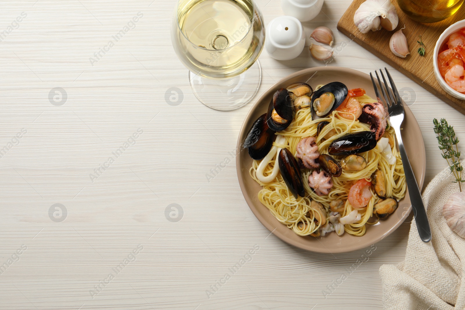 Photo of Delicious pasta with sea food served on white wooden table, flat lay. Space for text