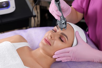 Photo of Young woman undergoing cosmetic procedure in beauty salon. Microcurrent therapy