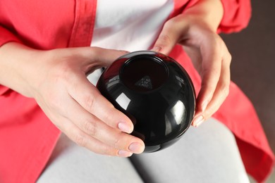 Woman holding magic eight ball with prediction Don't Bet On It, closeup