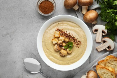 Delicious cream soup with mushrooms and croutons on beige textured table, flat lay. Space for text