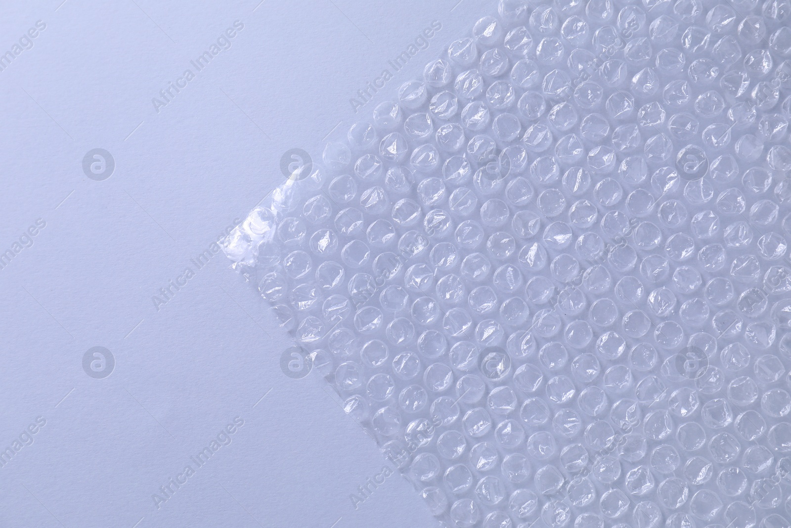 Photo of Transparent bubble wrap on gray background, top view. Space for text