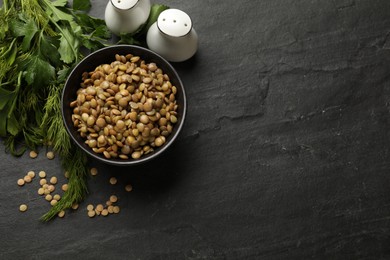 Photo of Delicious lentils in bowl with parsley and dill on grey textured table, flat lay. Space for text