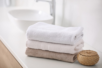 Photo of Stack of fresh towels on countertop in bathroom