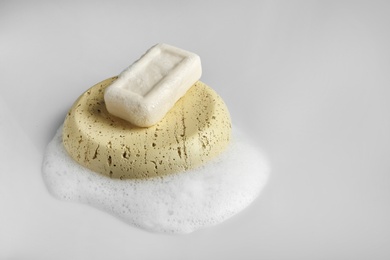 Soap dish with bar and foam on white background