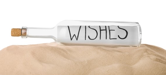 Photo of Corked glass bottle with Wishes note on sand against white background