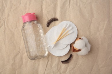 Photo of Flat lay composition with makeup remover and false eyelashes on crumpled paper