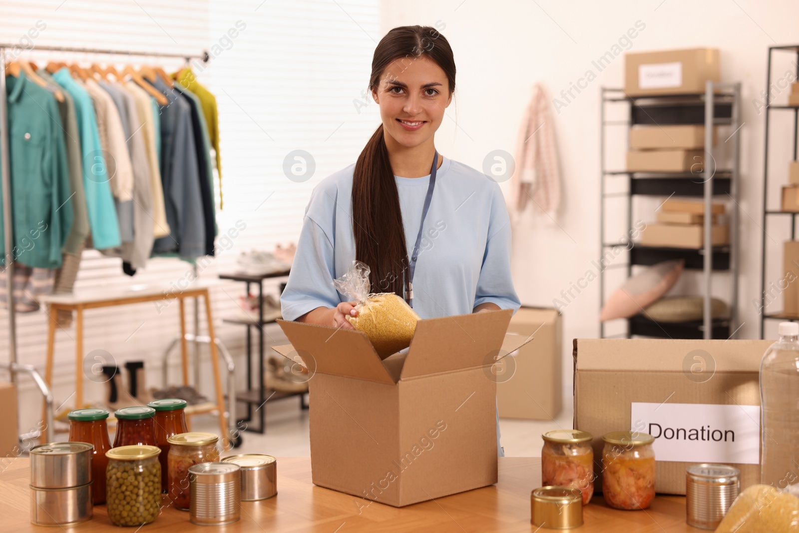 Photo of Volunteer packing food products at table in warehouse