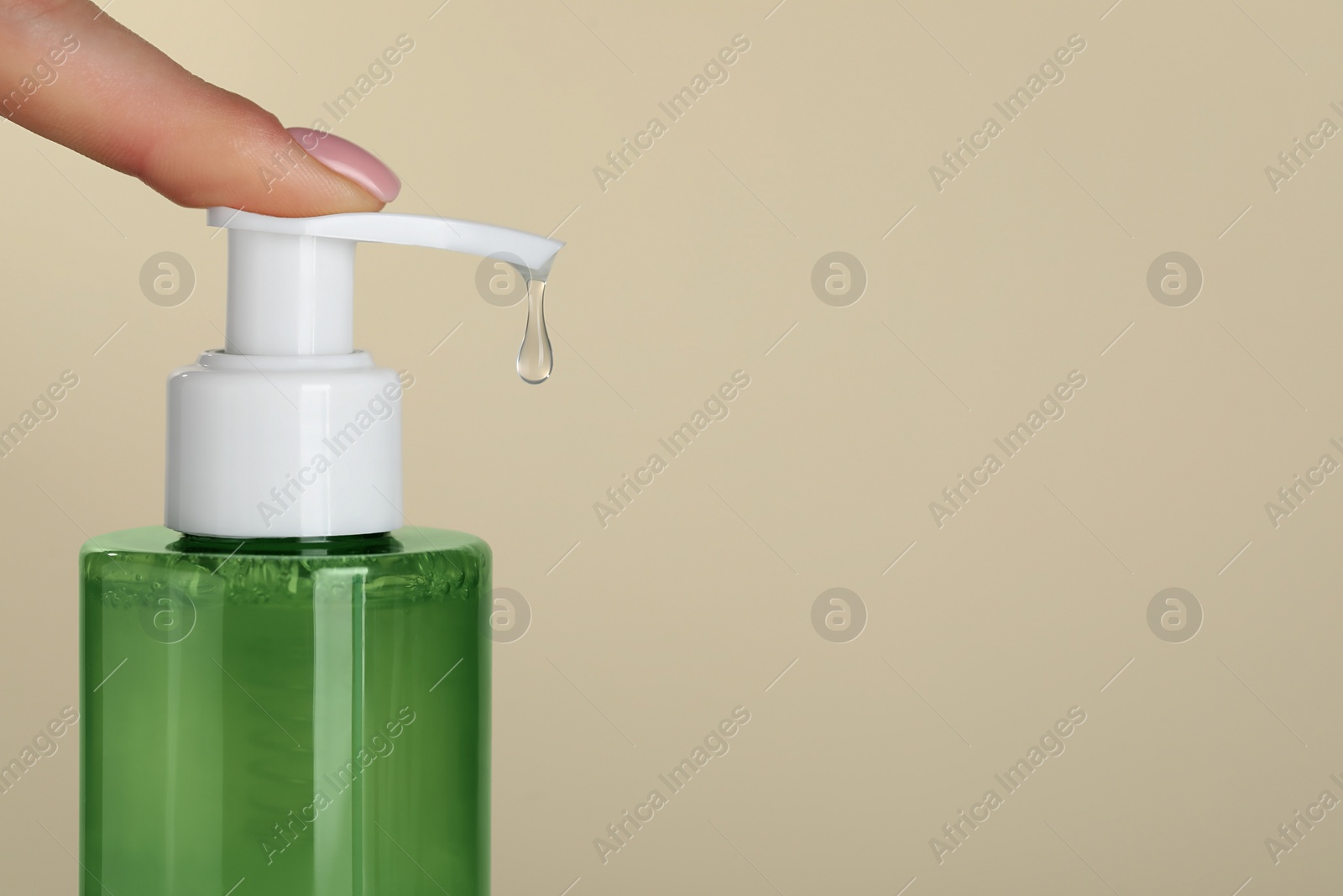 Photo of Woman using cleansing gel on beige background, closeup. Space for text