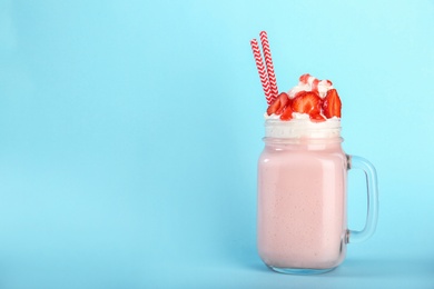 Photo of Mason jar with delicious milk shake on color background