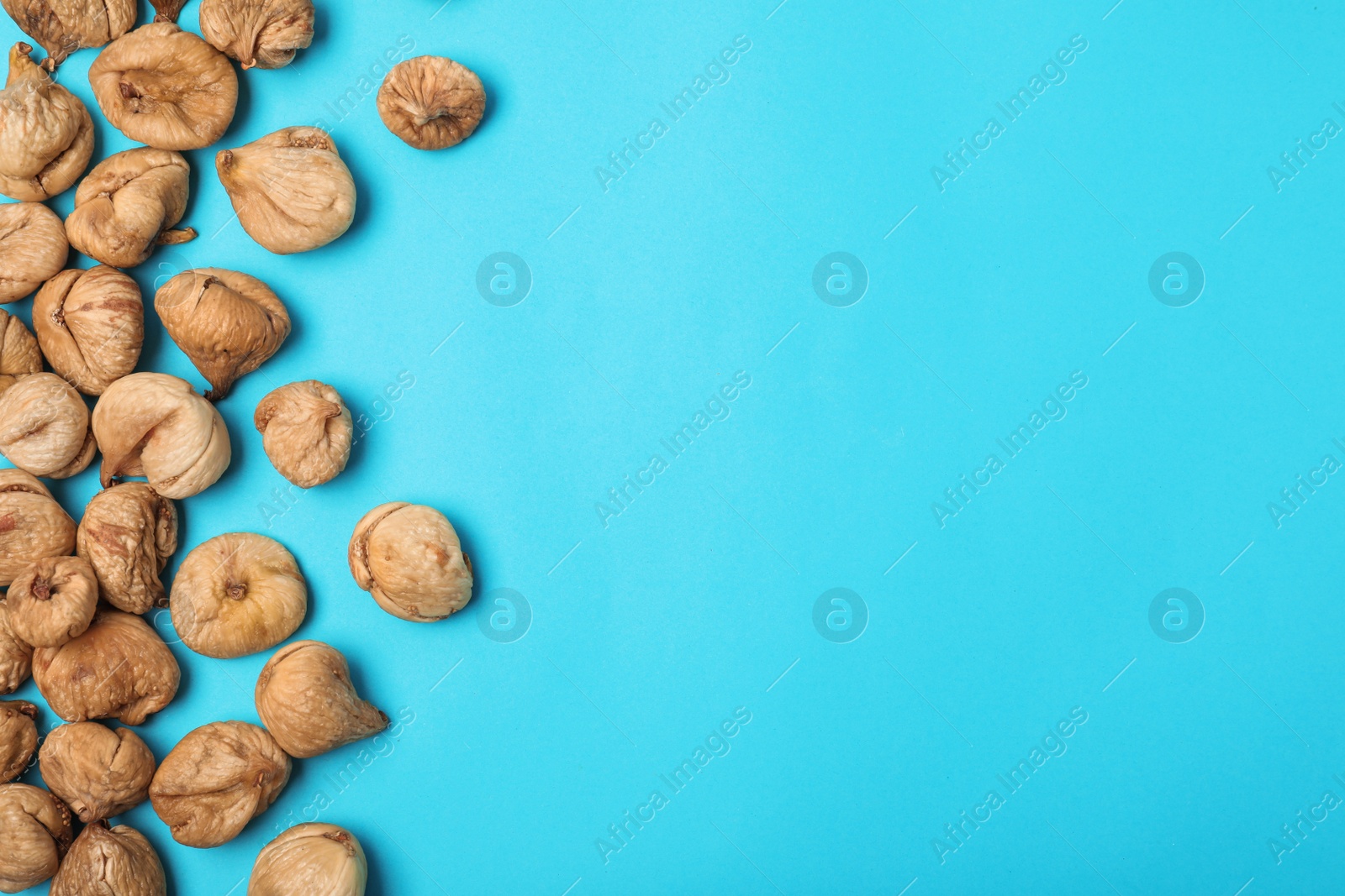 Photo of Dried figs on color background, top view with space for text. Healthy fruit