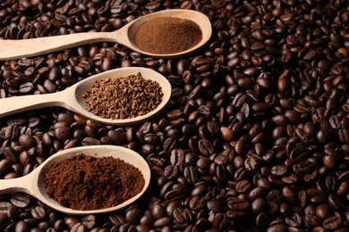 Photo of Spoons with different types of coffee on roasted beans. Space for text