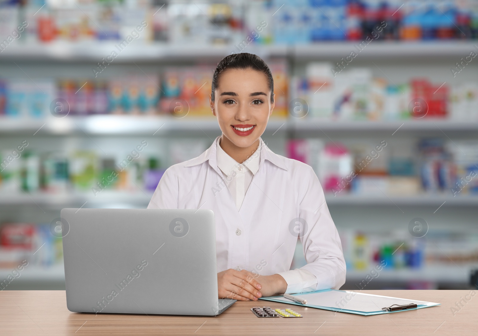 Image of Professional pharmacist working at table in modern drugstore 