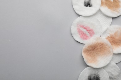 Photo of Dirty cotton pads after removing makeup on light grey background, flat lay. Space for text