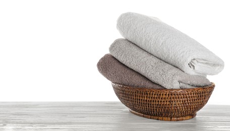 Fresh towels on wooden table against white background. Space for text