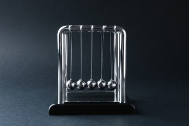 Photo of Newton's cradle on dark background. Physics law of energy conservation