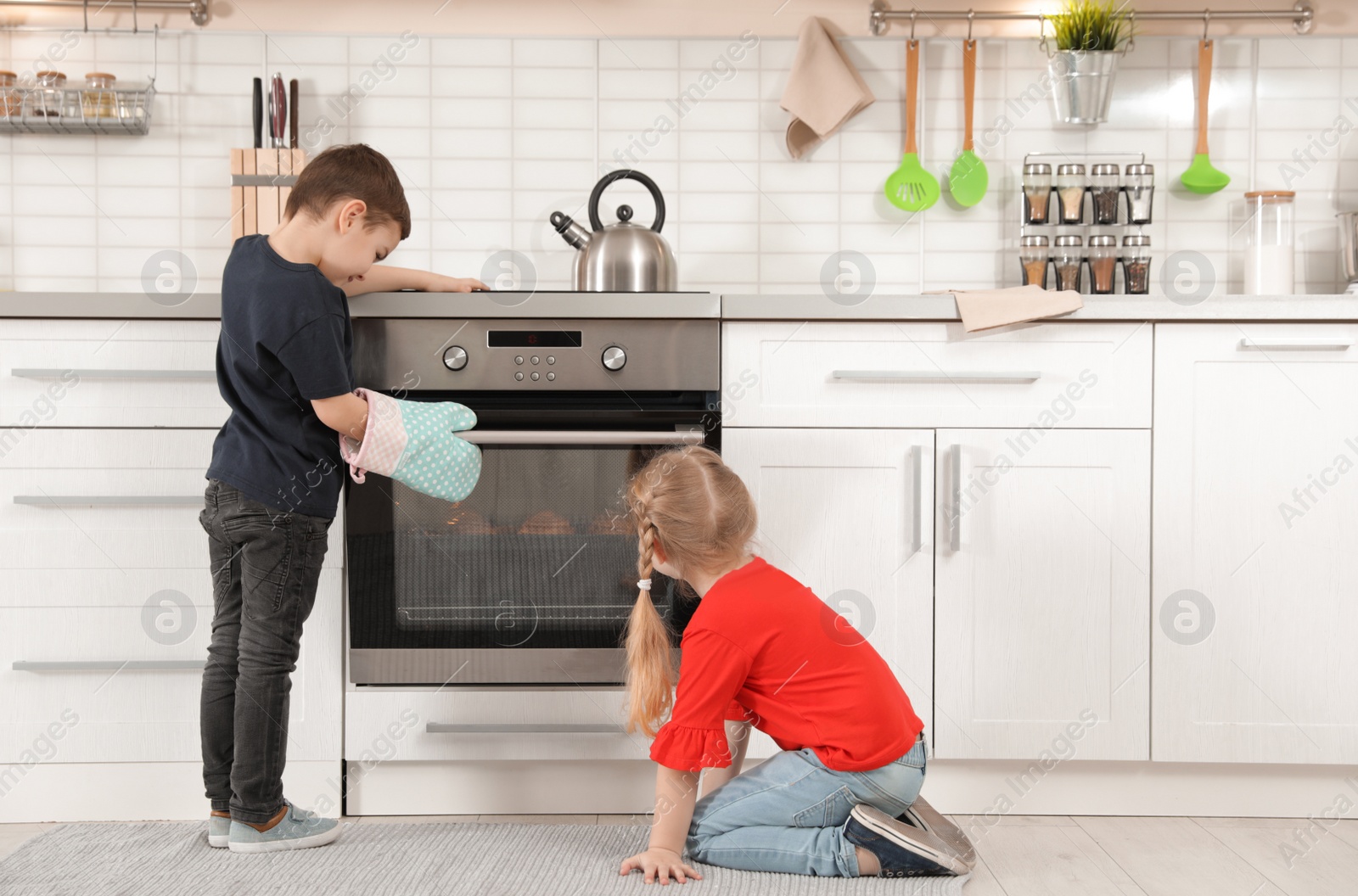 Photo of Little kids baking buns in oven at home