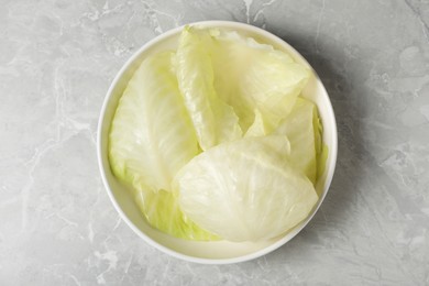 Cooked leaves for stuffed cabbage rolls on light grey table, top view