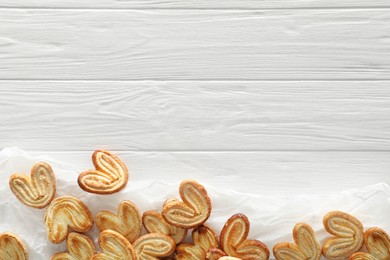 Photo of Food photography. Delicious french palmier cookies on white wooden table, flat lay and space for text