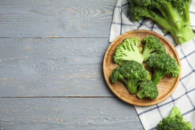 Photo of Fresh green broccoli on wooden table, flat lay. Space for text