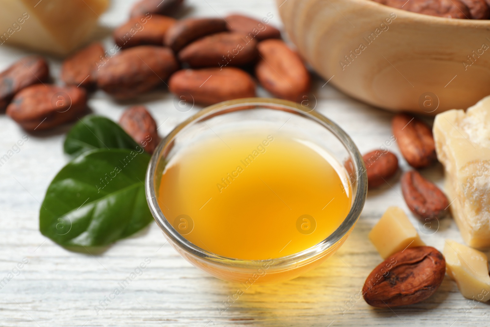 Photo of Organic cocoa butter on white wooden table, closeup