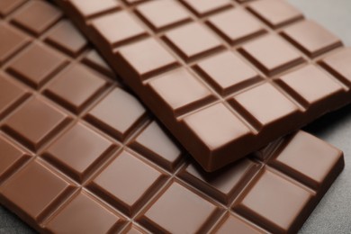 Photo of Delicious milk chocolate bars on table, closeup