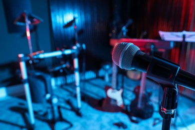 Photo of Modern microphone at recording studio, color toned. Music band practice