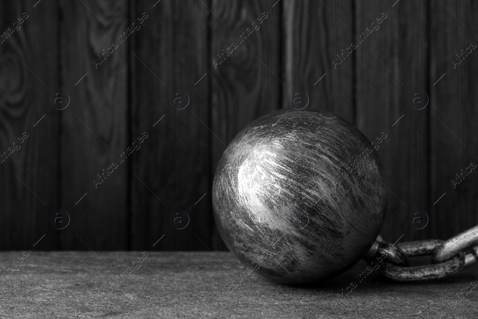 Photo of Prisoner ball with chain on grey table, space for text