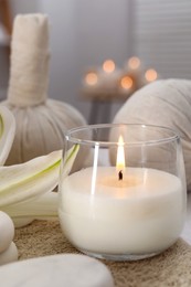 Photo of Spa composition with burning candle and herbal bags on massage table in wellness center