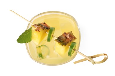 Photo of Glass of tasty pineapple cocktail with sliced fruit, mint and chili pepper isolated on white, top view