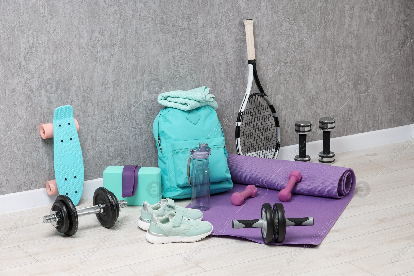 Photo of Many different sports equipment near grey wall indoors