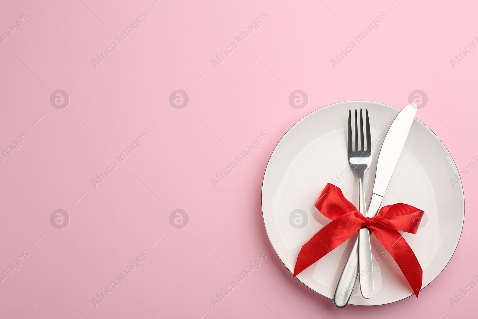 Photo of Beautiful table setting on pink background, top view with space for text. Valentine's Day dinner