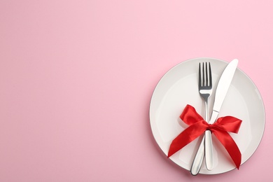 Photo of Beautiful table setting on pink background, top view with space for text. Valentine's Day dinner