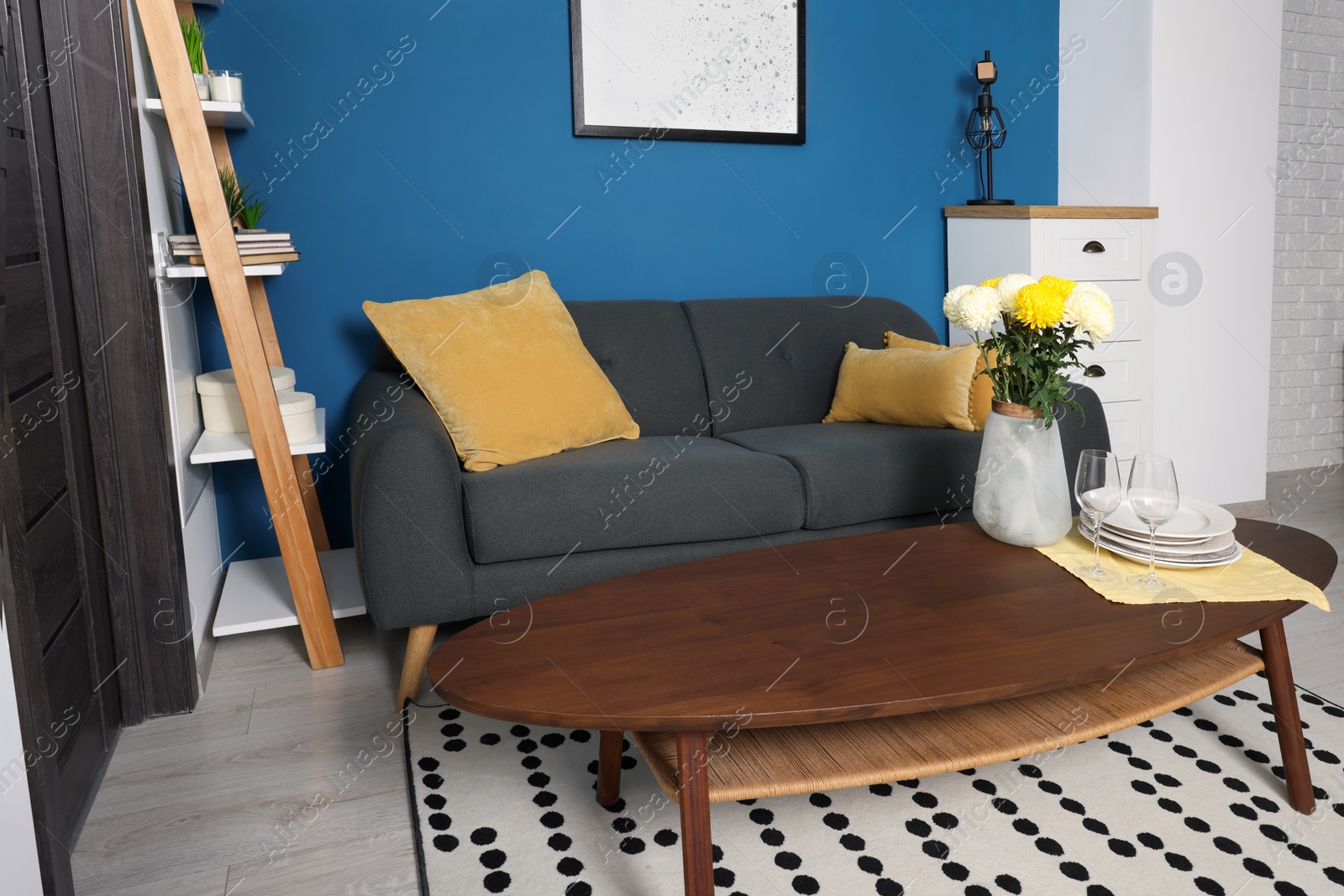 Photo of Stylish living room interior with comfortable grey sofa and coffee table