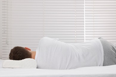 Photo of Man sleeping on orthopedic pillow at home