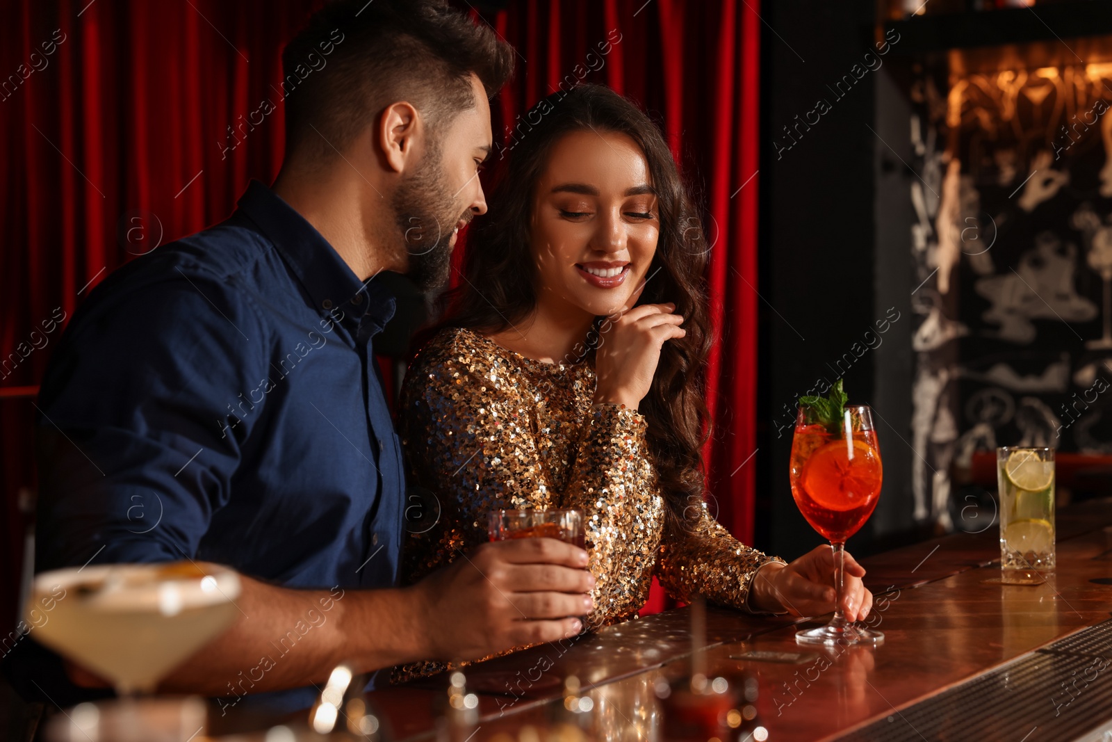 Photo of Lovely couple with fresh cocktails at bar counter