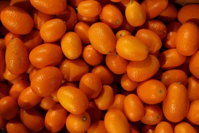 Photo of Many fresh kumquats as background, top view