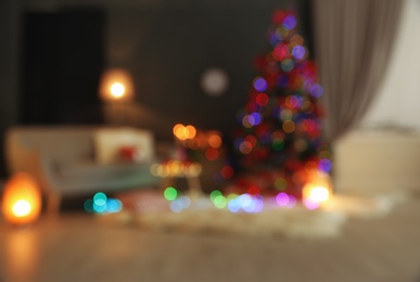 Photo of Blurred view of stylish room interior with decorated Christmas tree