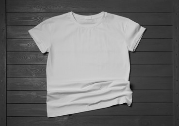 Stylish white T-shirt on gray wooden table, top view